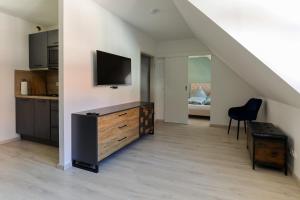 een woonkamer met een dressoir met een tv aan de muur bij Ferienwohnung hinter der Krämerbrücke in Erfurt