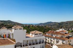 vista sui tetti delle case e sulle montagne di Apartamento rural Alborada a Cómpeta