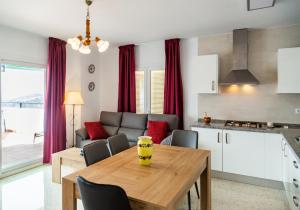kuchnia i salon z drewnianym stołem i krzesłami w obiekcie Apartamento rural Alborada w mieście Cómpeta