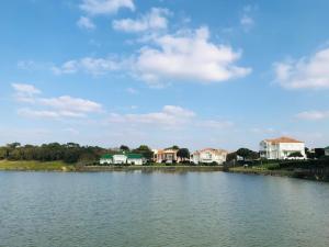 a view of a lake with houses in the background at Studio du golf, standing, piscine, forêt et océan in Saint-Jean-de-Monts