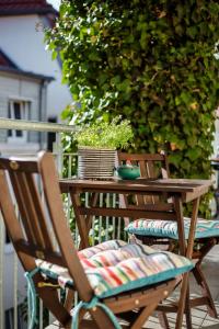 een houten tafel met twee stoelen en een potplant bij Ferienwohnung hinter der Krämerbrücke in Erfurt