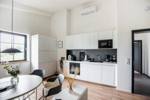 a kitchen with white cabinets and a table and chairs at Apart Hüsske 2 in Krefeld