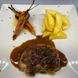 a plate of food with a steak and fries at Hostal Ezkaurre in Isaba