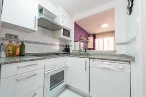 a white kitchen with a sink and a dishwasher at Martín- Bungalow a pie de playa V7 in Calpe