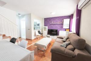 a living room with a couch and a tv at Martín- Bungalow a pie de playa V7 in Calpe