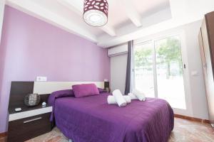 a purple bedroom with a purple bed and a window at Martín- Bungalow a pie de playa V7 in Calpe