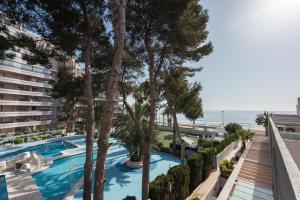 an apartment with a swimming pool and palm trees at Martín- Bungalow a pie de playa V7 in Calpe