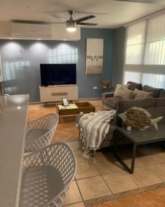 a living room with a couch and a tv at Mar Azul Bay View Apartment in Boqueron