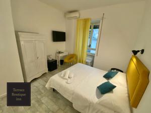 um quarto com uma cama branca e uma cabeceira amarela em Terrace Boutique Inn em Roma
