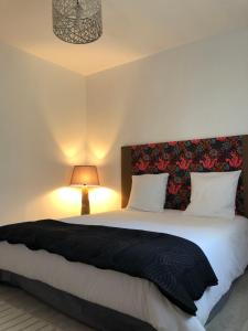 een slaapkamer met een groot bed en een zwarte deken bij Chambres d'Elisa in Saint-Morillon