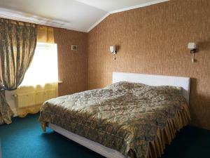 Schlafzimmer mit einem Bett und einem Fenster in der Unterkunft Avtoport Restorant Hotel Complex in Winnyzja