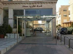 una entrada a un edificio con una puerta de cristal en Al Thuraya Hotel, en Amán