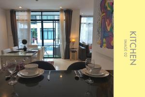 a dining room with a table with wine glasses on it at Pool Access 2 BDR Stylish Condo in Kamala Beach