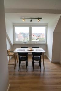 a dining room with a table and chairs and a window at Ferienwohnung Hallighafen in Bredstedt