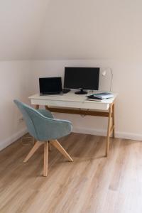un escritorio con una silla y un ordenador. en Ferienwohnung Hallighafen, en Bredstedt