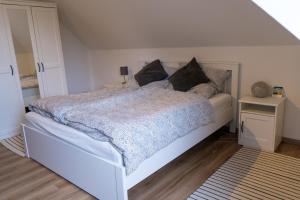 a bedroom with a large white bed with pillows at Ferienwohnung Hallighafen in Bredstedt