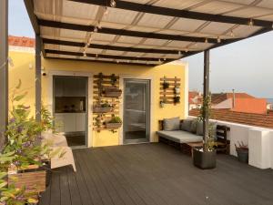 a patio with a couch under a pergola at Day Off Suite&Hostel in Setúbal