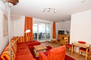 a living room with a couch and a table at Hafenhäuser Wiek FeWo 06 - Balkon, Meerblick in Wiek auf Rügen 