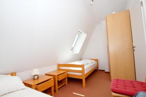 a bedroom with two beds and a chair and a window at Hafenhäuser Wiek FeWo 06 - Balkon, Meerblick in Wiek auf Rügen 