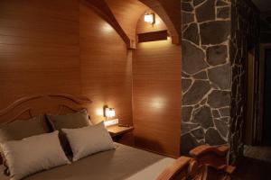 1 dormitorio con cama y pared de piedra en Pidkova, en Rivne