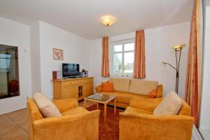 TV a/nebo společenská místnost v ubytování hafennahe Ferienwohnung mit Balkon und Meerblick - Hafenhäuser Wiek FeWo Wohnung 01