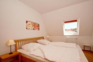 Postel nebo postele na pokoji v ubytování hafennahe Ferienwohnung mit Balkon und Meerblick - Hafenhäuser Wiek FeWo Wohnung 01