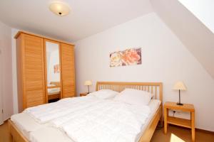 Postel nebo postele na pokoji v ubytování hafennahe Ferienwohnung mit Balkon und Meerblick - Hafenhäuser Wiek FeWo Wohnung 01