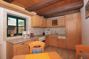 ヴィーク・アウフ・リューゲンにあるFerienhaus Storchennest Haus Terrasse, Gartenのキッチン(木製のキャビネット、テーブル付)