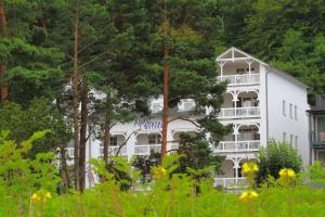 a white building with trees in front of it at Aparthotel Ostsee FeWo 31 Balkon, Meerblick, Strand in Binz