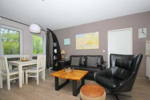 ein Wohnzimmer mit Sofa und Tisch in der Unterkunft strandnah mit Terrasse, gratis Nutzung vom AHOI Erlebnisbad und Sauna in Sellin - Strandhaus Mönchgut FeWo09 in Lobbe
