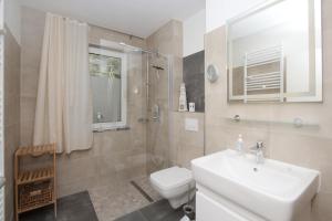 ein Badezimmer mit Waschbecken, Toilette und Dusche in der Unterkunft strandnah mit Terrasse, gratis Nutzung vom AHOI Erlebnisbad und Sauna in Sellin - Strandhaus Mönchgut FeWo09 in Lobbe