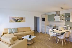 ein Wohnzimmer mit Sofa und Tisch in der Unterkunft strandnah mit Balkon, gratis Nutzung vom AHOI Erlebnisbad und Sauna in Sellin - Strandhaus Mönchgut FeWo13 in Lobbe