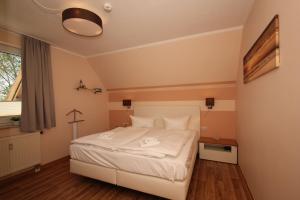 ein Schlafzimmer mit einem weißen Bett und einem Fenster in der Unterkunft strandnah mit Balkon, gratis Nutzung vom AHOI Erlebnisbad und Sauna in Sellin - Strandhaus Mönchgut FeWo13 in Lobbe + 15 Fotos