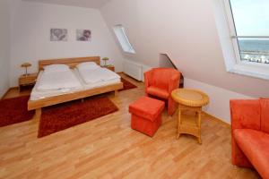 a small room with a bed and a chair at Hafenhäuser Wiek FeWo 11 - Balkon, Meerblick in Wiek auf Rügen