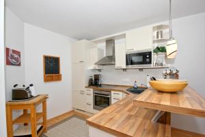 Kuchyň nebo kuchyňský kout v ubytování hafennahe Ferienwohnung mit Balkon und Meerblick - Hafenhäuser Wiek Wohnung 14 + 13 fotografií
