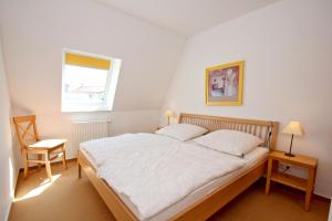 Postel nebo postele na pokoji v ubytování hafennahe Ferienwohnung mit Balkon und Meerblick - Hafenhäuser Wiek FeWo Wohnung 03
