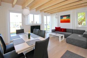 sala de estar con mesa y sofá en hafennahes Ferienhaus mit Terrasse und Meerblick - Ferienhaus TimpeTe Steuerbord, en Gager