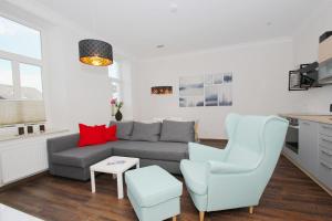 ein Wohnzimmer mit einer Couch, einem Sessel und einem Tisch in der Unterkunft Ferienwohnung mit eigener Sauna in zentraler Lage - Kurhaus Nordstrand FeWo 32 in Göhren