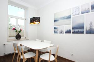 ein Esszimmer mit einem weißen Tisch und Stühlen in der Unterkunft Ferienwohnung mit eigener Sauna in zentraler Lage - Kurhaus Nordstrand FeWo 32 in Göhren