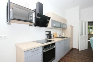 eine Küche mit weißen Schränken und einer Arbeitsplatte in der Unterkunft Ferienwohnung mit eigener Sauna in zentraler Lage - Kurhaus Nordstrand FeWo 32 in Göhren + 13 Fotos