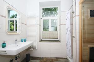 ein weißes Badezimmer mit Waschbecken und Fenster in der Unterkunft Ferienwohnung mit eigener Sauna in zentraler Lage - Kurhaus Nordstrand FeWo 32 in Göhren