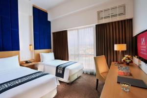 Postel nebo postele na pokoji v ubytování Swiss-Belinn Malang