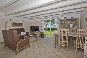 a living room with a table and chairs and a couch at strandnahe Idylle am Meer, private Badestelle, Strandkorb - Gutshof Ostseeblick in Neuendorf