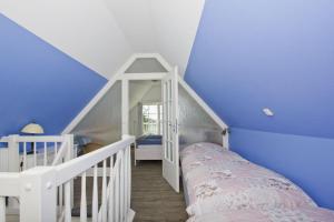 a bedroom with blue walls and a bed with a ladder at strandnahe Idylle am Meer, private Badestelle, Strandkorb - Gutshof Ostseeblick in Neuendorf