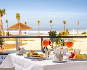 - une table avec de la nourriture et une vue sur la plage dans l'établissement Zephyr Mazagan, à El Jadida