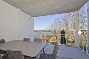 une salle à manger avec une table, des chaises et une grande fenêtre dans l'établissement Ferienwohnung mit Balkon, Kamin und Sauna - Ferienresidenz Zwei Bodden FeWo 2-9, à Lietzow