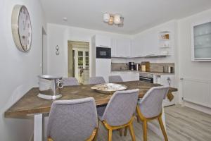 a kitchen with a wooden table with chairs and a counter at Ferienwohnung mit Balkon, Kamin und Sauna - Ferienresidenz Zwei Bodden FeWo 2-9 in Lietzow +12 photos