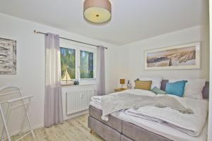 Un pat sau paturi într-o cameră la Ferienwohnung mit Balkon, Kamin und Sauna - Ferienresidenz Zwei Bodden FeWo 2-9