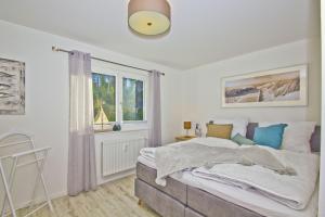 - une chambre avec un grand lit et une fenêtre dans l'établissement Ferienwohnung mit Balkon, Kamin und Sauna - Ferienresidenz Zwei Bodden FeWo 2-9, à Lietzow