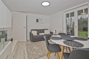 a living room with a table and chairs and a couch at moderne Ferienwohnung mit Sauna und Terrasse - Ferienresidenz Zwei Bodden 112 in Lietzow